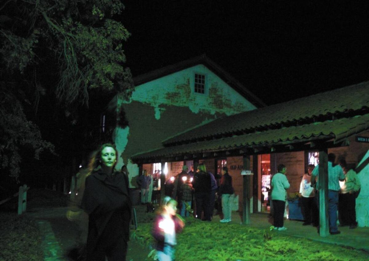 Vickie Carroll of Templeton and her daughter, Madeleine, walk near the Rios-Caledonia Adobe in San Miguel. Visitors can take candlelight tours of the adobe on Oct. 28.