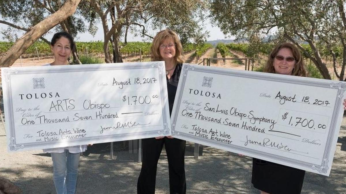 Angela Tahti, left, officially ended her tenure as executive director of Arts Obispo, the San Luis Obispo County Arts Council, on Monday. She poses for a photo with June McIvor, general manager of Tolosa Winery in San Luis Obispo, and Catherine Lansdowne, executive director of the San Luis Obispo Symphony, with giant checks signifying donations from the Tolosa Art Wine Music Encounter.