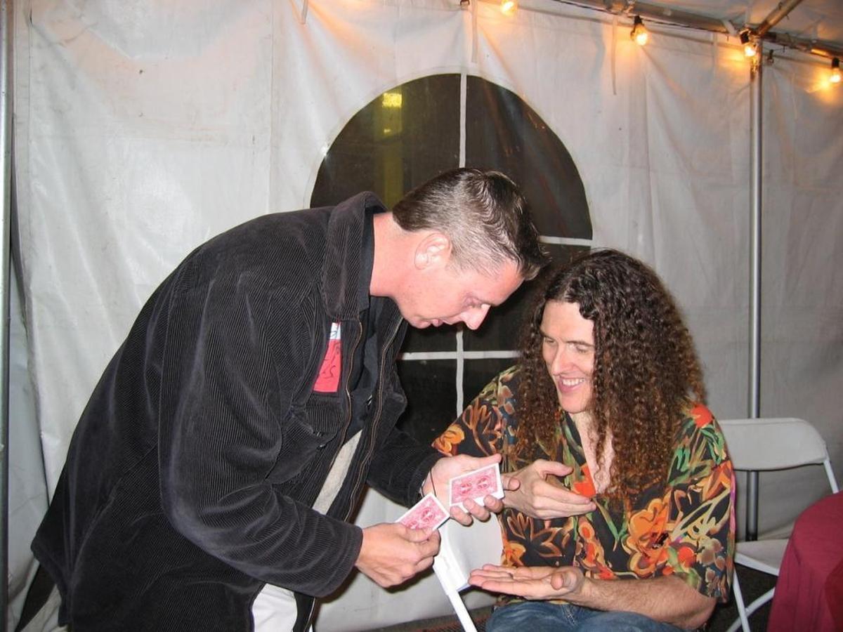 San Luis Obispo entertainer Rich Ferguson performs a card trick for parody music artist “Weird Al” Yankovic. Like Yankovic, Ferguson attended Cal Poly.