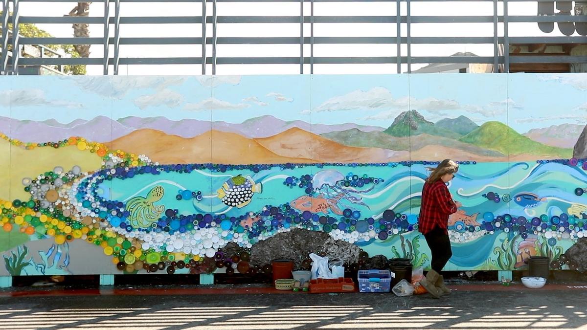 Ingrid Goelz, a founding member of the Cayucos Art Association, is using recycled plastic lids to make an ocean-themed mural on the side of the Cayucos skate park.