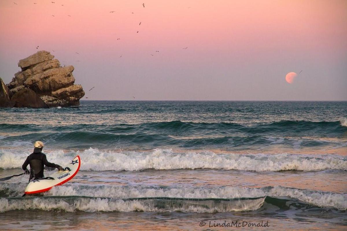 The moon sets just north of Morro Rock.