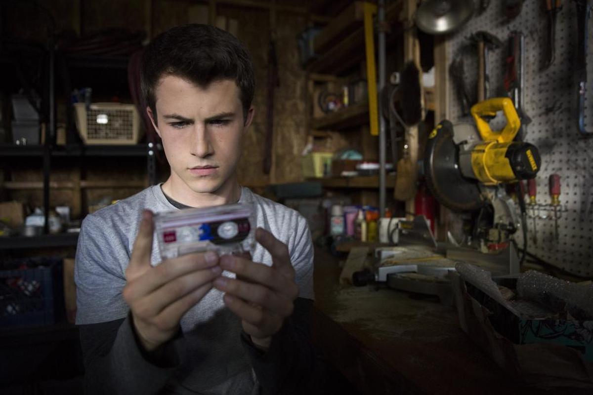 High school student Clay (Dylan Minette) examines a cassette tape sent to him by a former classmate in a scene from Netflix show “13 Reasons Why.” The series, based on Jay Asher’s best-selling book “Thirteen Reasons Why,” returns for a second season in 2018.