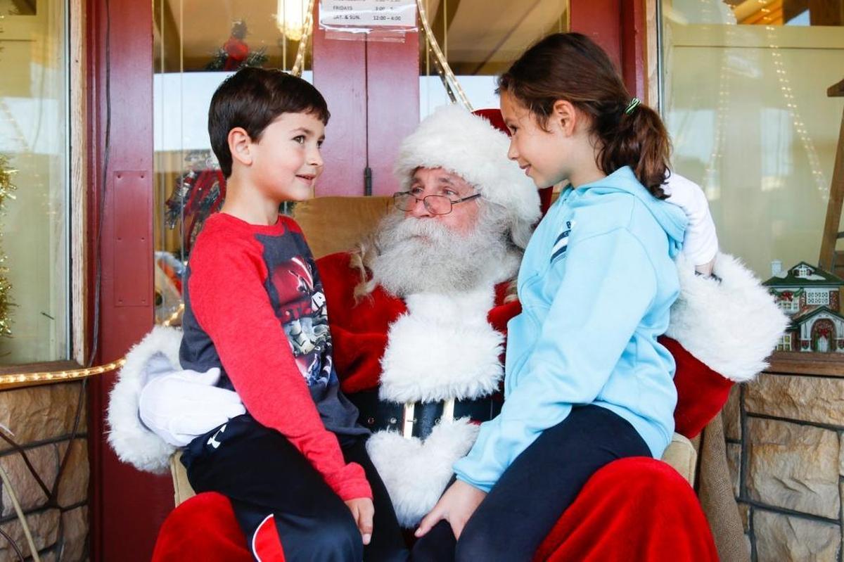 Jack Von Biela, a close friend of Santa Claus, talks to Morgan Korth, 10, and her brother Lucas, 8, both of Arroyo Grande. St. Nick returns to the Village of Arroyo Grande on Friday.