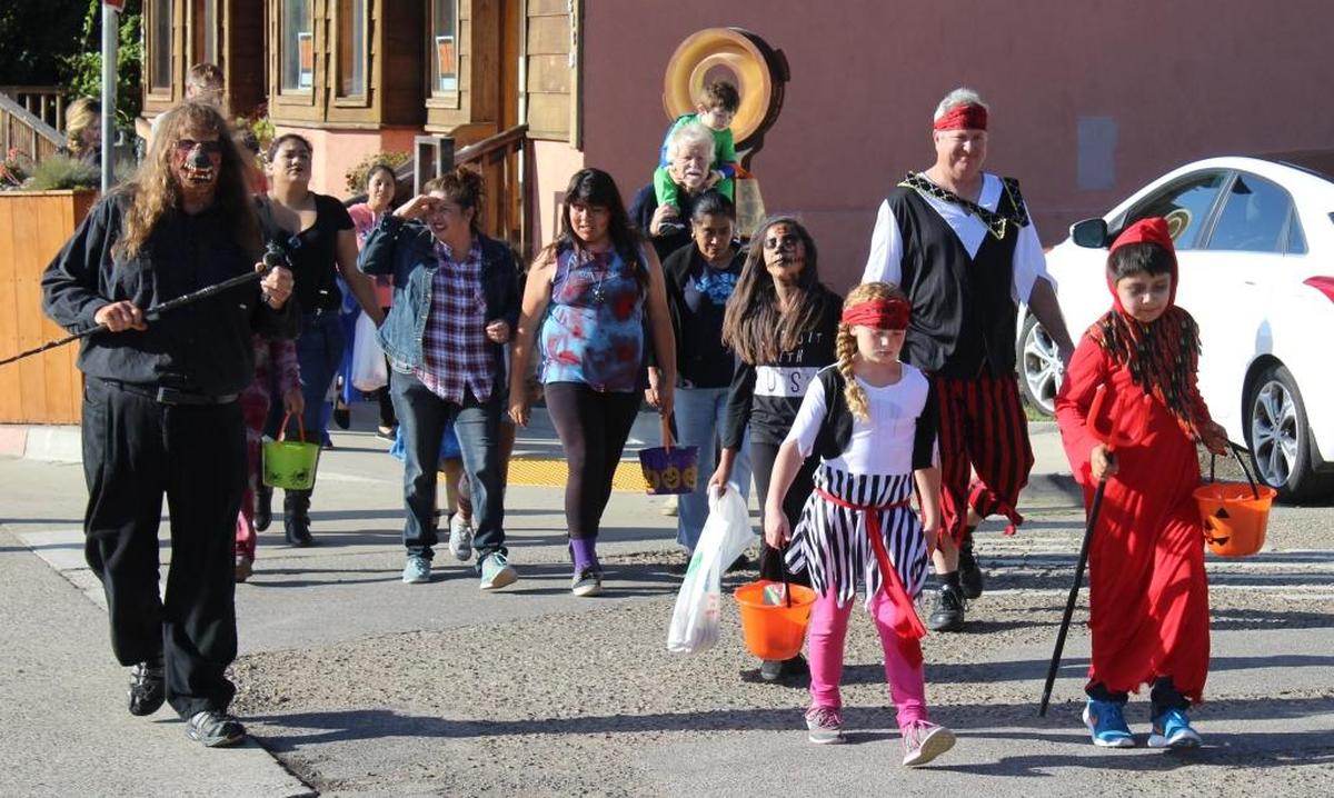 Village Wizard Rick Bruce, left, leads a line of trick-or-treaters up Main Street in Cambria's West Village during the annual Halloween parade.