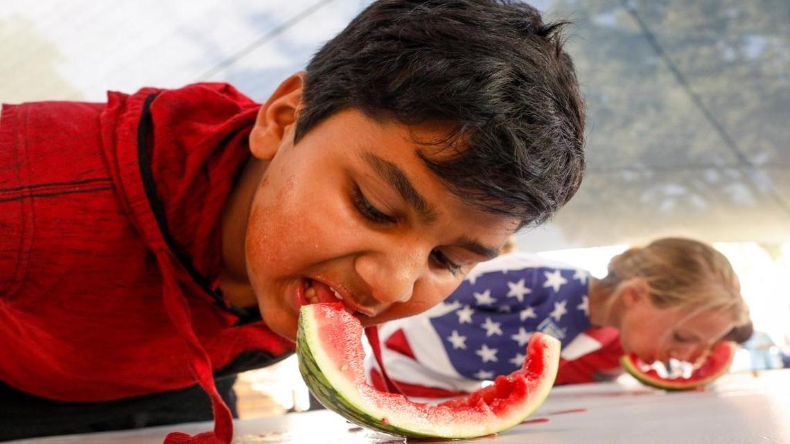 Krish Patel, 13, mows down his watermelon on the way to a first-place finish in the junior division of the watermelon eating contest at the California Mid-State Fair in Paso Robles.