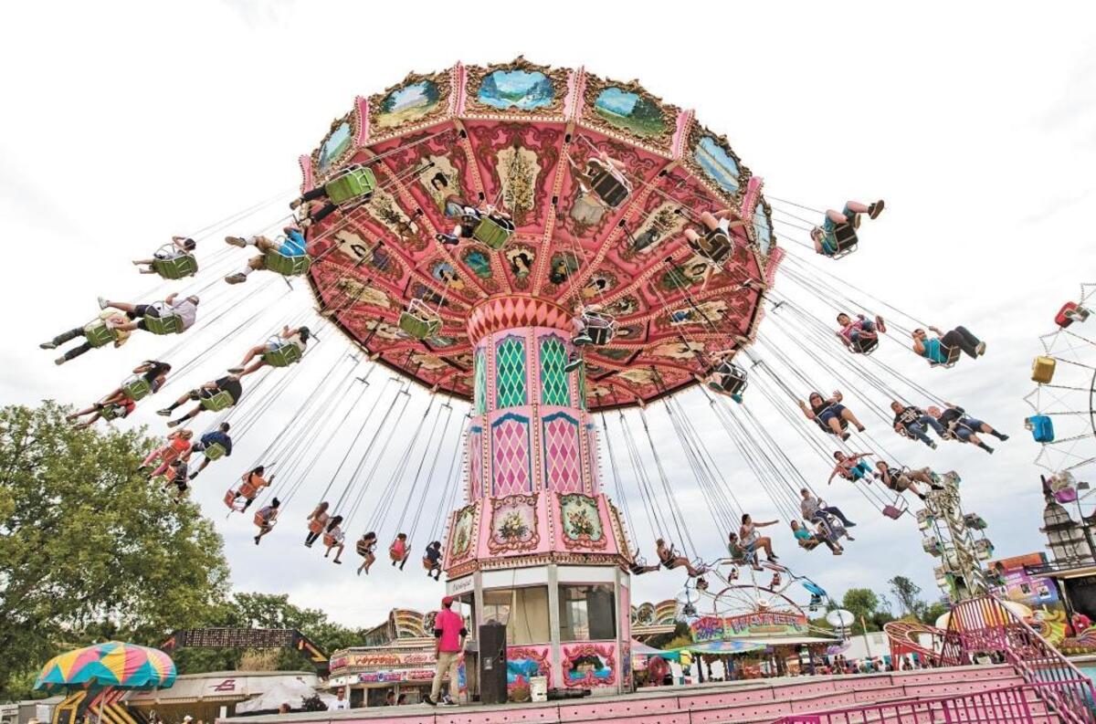 Fairgoers sail through the air while riding the Oktoberfest Wave Swinger at the California Mid-State Fair in Paso Robles.