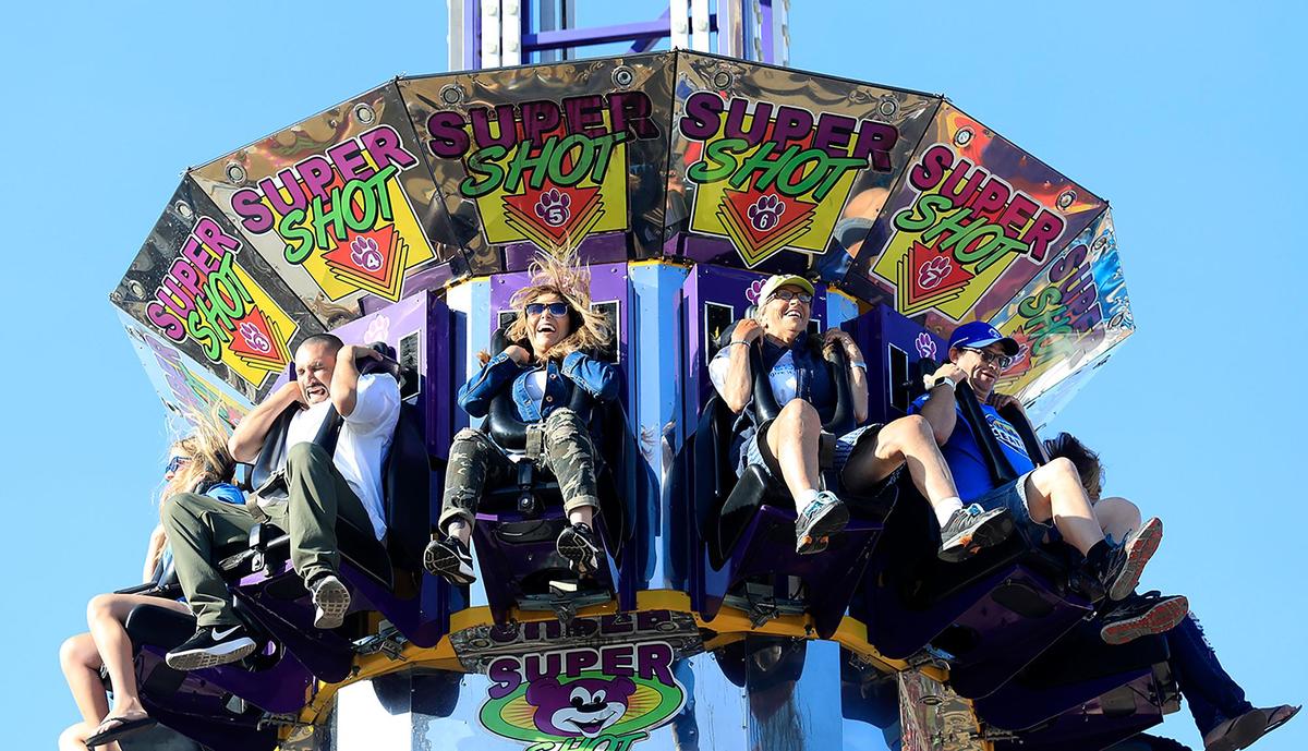 Sonia Marin, center, and friend Luis Maya, left, scream as the Super Shot ride zooms down the tower. Both are from Santa Maria. The Super Shot is an example of a ride that capitalizes on the effect of gravity to deliver thrills.