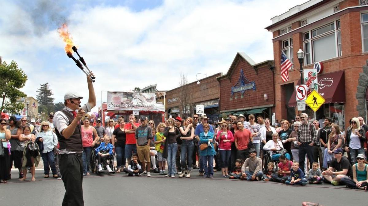 A fire-wielding juggler entertains the crowd at the Arroyo Grande Strawberry Festival in 2015.