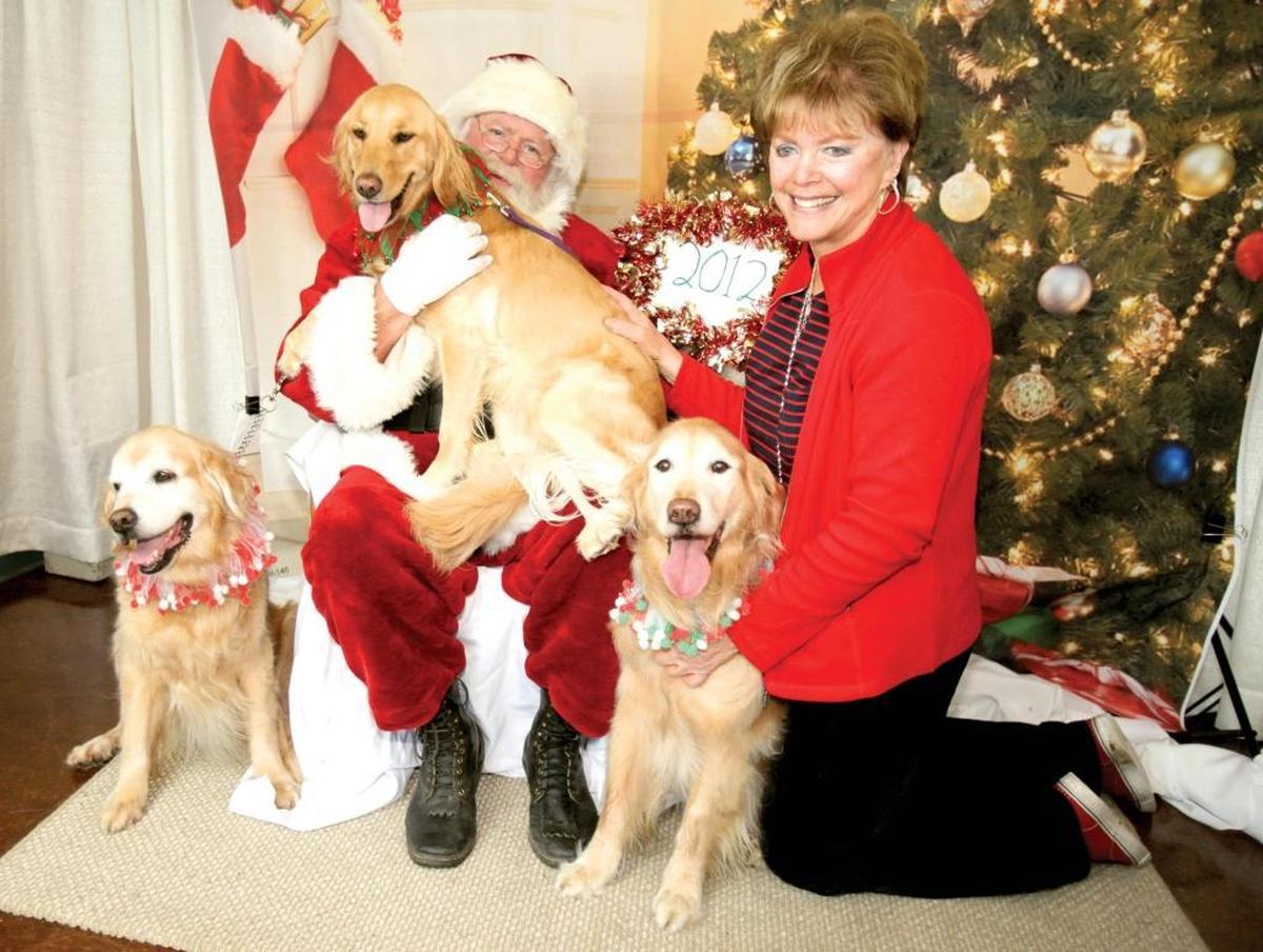 Kate Shurson of Pismo Beach and her golden retrievers — from left, 13-year-old Maya, 2-year-old Zeba, and 12-year-old Xochi — poses for a photo with Santa Claus at Woods Humane Society in San Luis Obispo. The human society holds its annual Holiday Open House on Dec. 9.