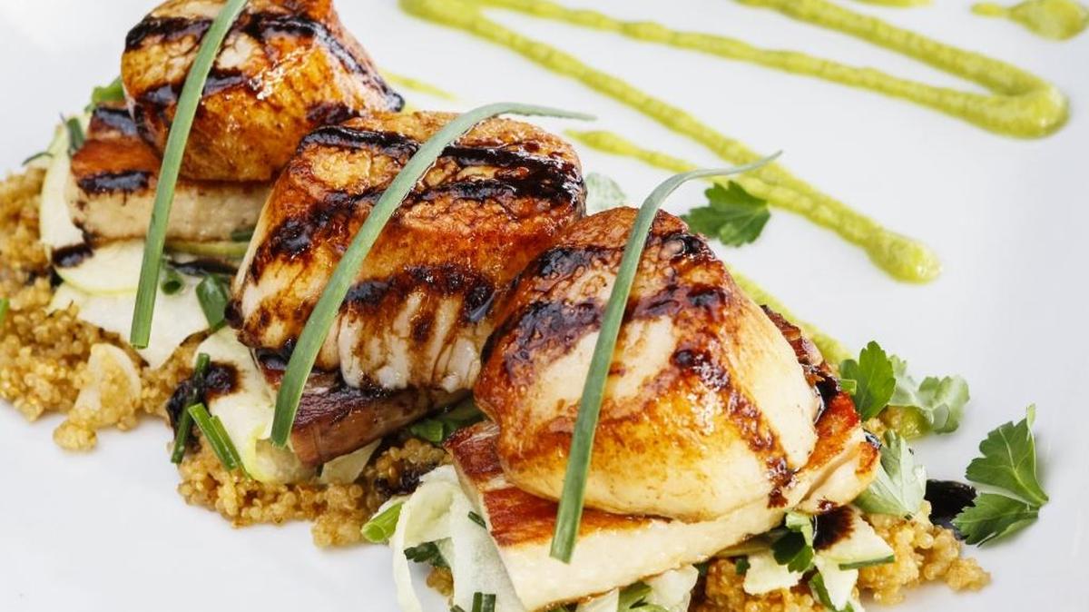 Seared diver scallops and pork belly are paired with miso quinoa, apple and an apple-fennel salad with an apple ginger vinaigrette and house-smoked bacon at Ocean Grill in Avila Beach.