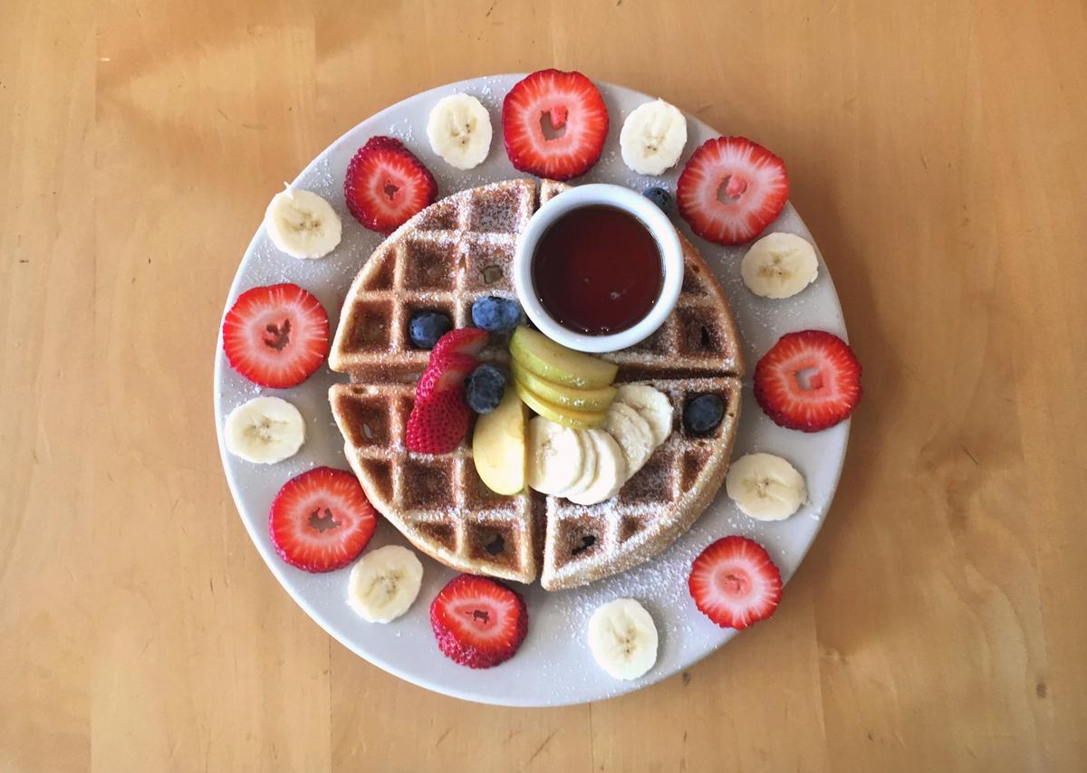 The Sally's Waffle is topped with maple syrup and fresh fruit at Sally Loo's Wholesome Cafe in San Luis Obispo.