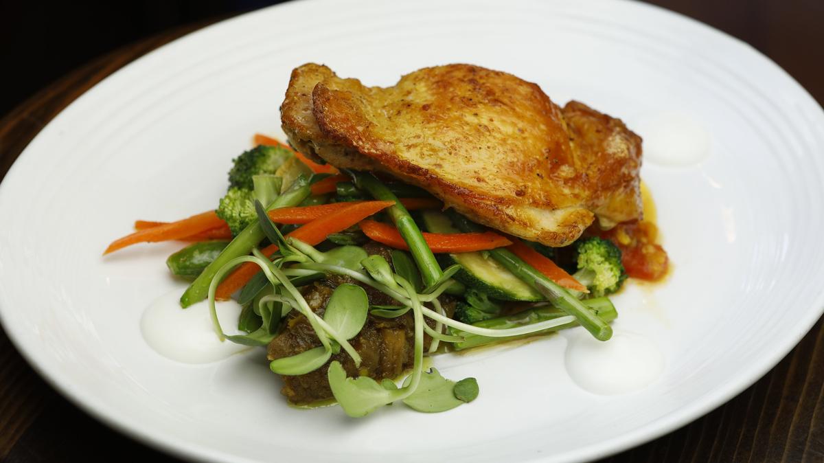 Indian spice-rubbed tandoori chicken is served with yellow lentil dahl, market veggies, eggplant chutney and yogurt at Mint + Craft Cafe and Mercantile in San Luis Obispo.
