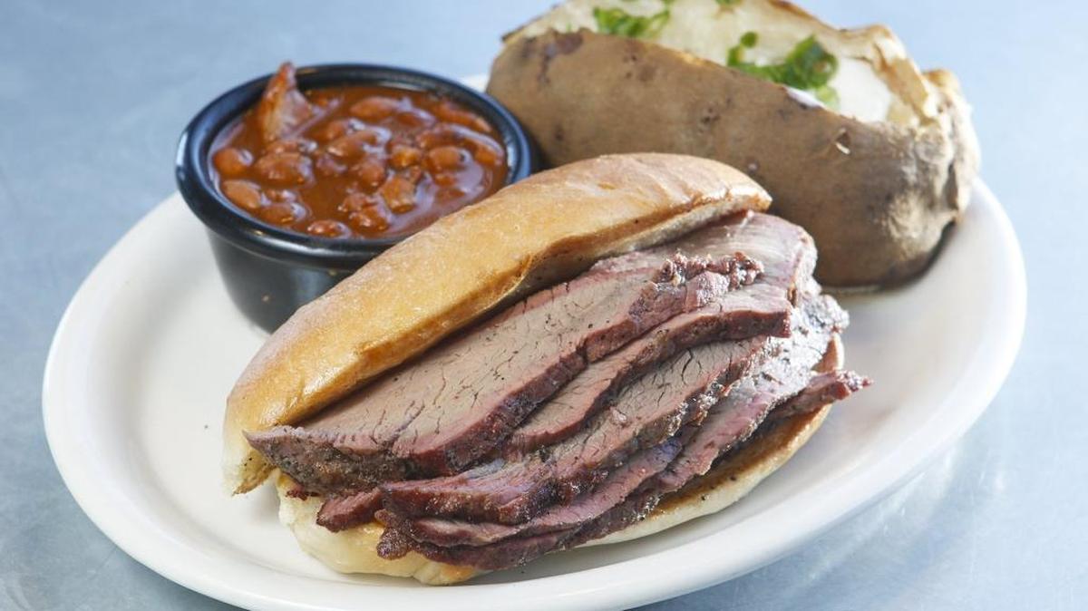 The tri-tip sandwich is shown here with ranch-style beans and baked potato, two of 12 possible side dishes.