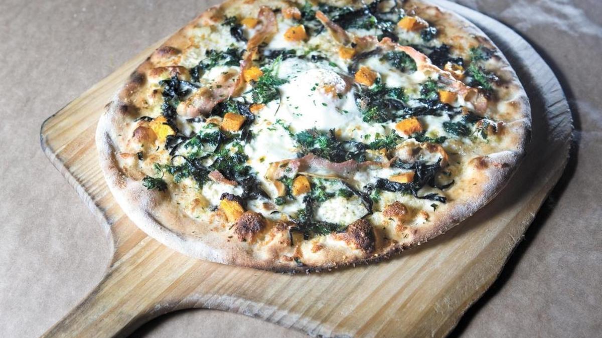 A pizza with black trumpet mushroom, nettles and farm egg, smokey white sauce, la quercia pancetta, butternut squash and garden thyme is served at Ember in Arroyo Grande. The restaurant was added to Michelin Guide California on Wednesday, Nov. 9, 2022.