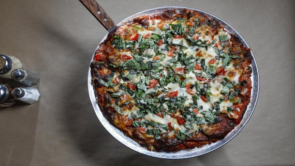 A pizza at Nardonne’s La Famiglia Pizzeria, which has locations in Atascadero and Los Osos, features tomatoes, basil, olives, onion, artichoke hearts and bell peppers.