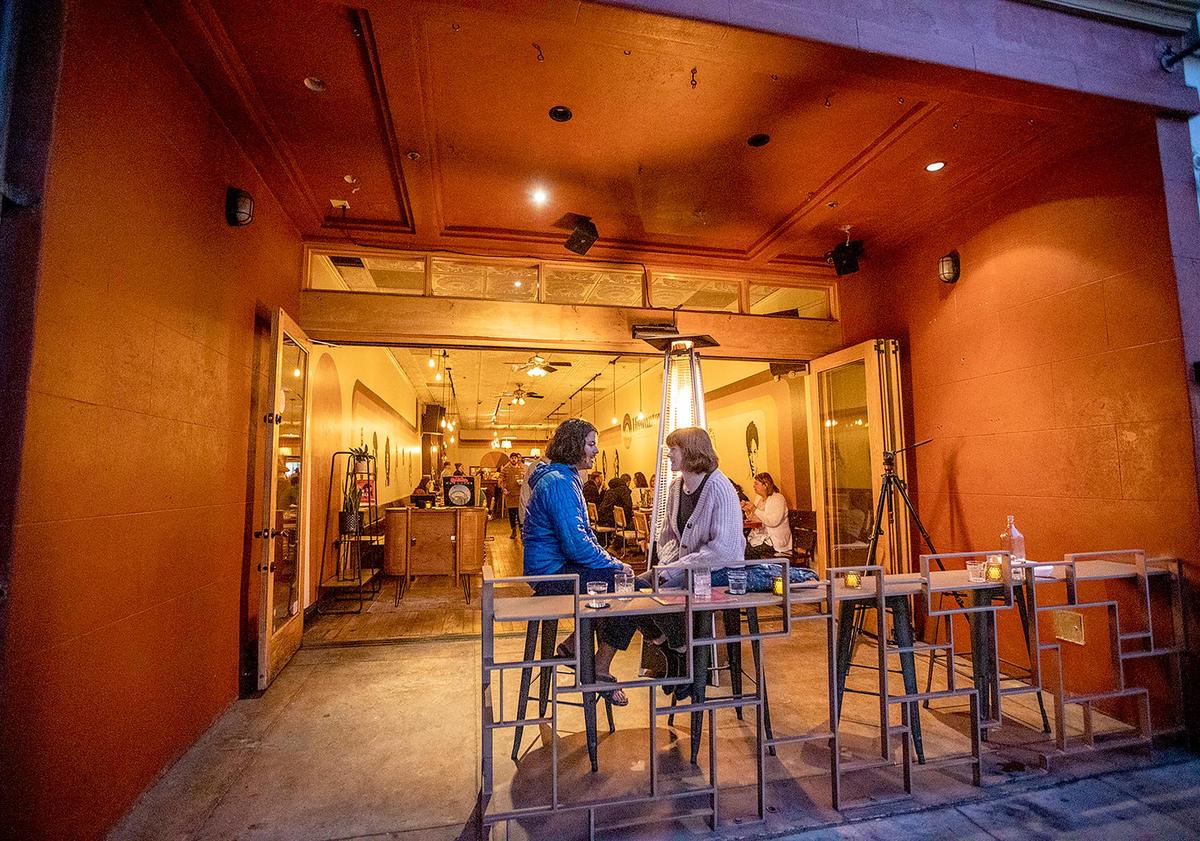 A couple chat on the heated front patio at Highwater, the venture of Robin Kirk Wolf and Matt Hanson, located at the old Sidecar location on Broad Street, a couple of doors down from Big Sky Cafe.