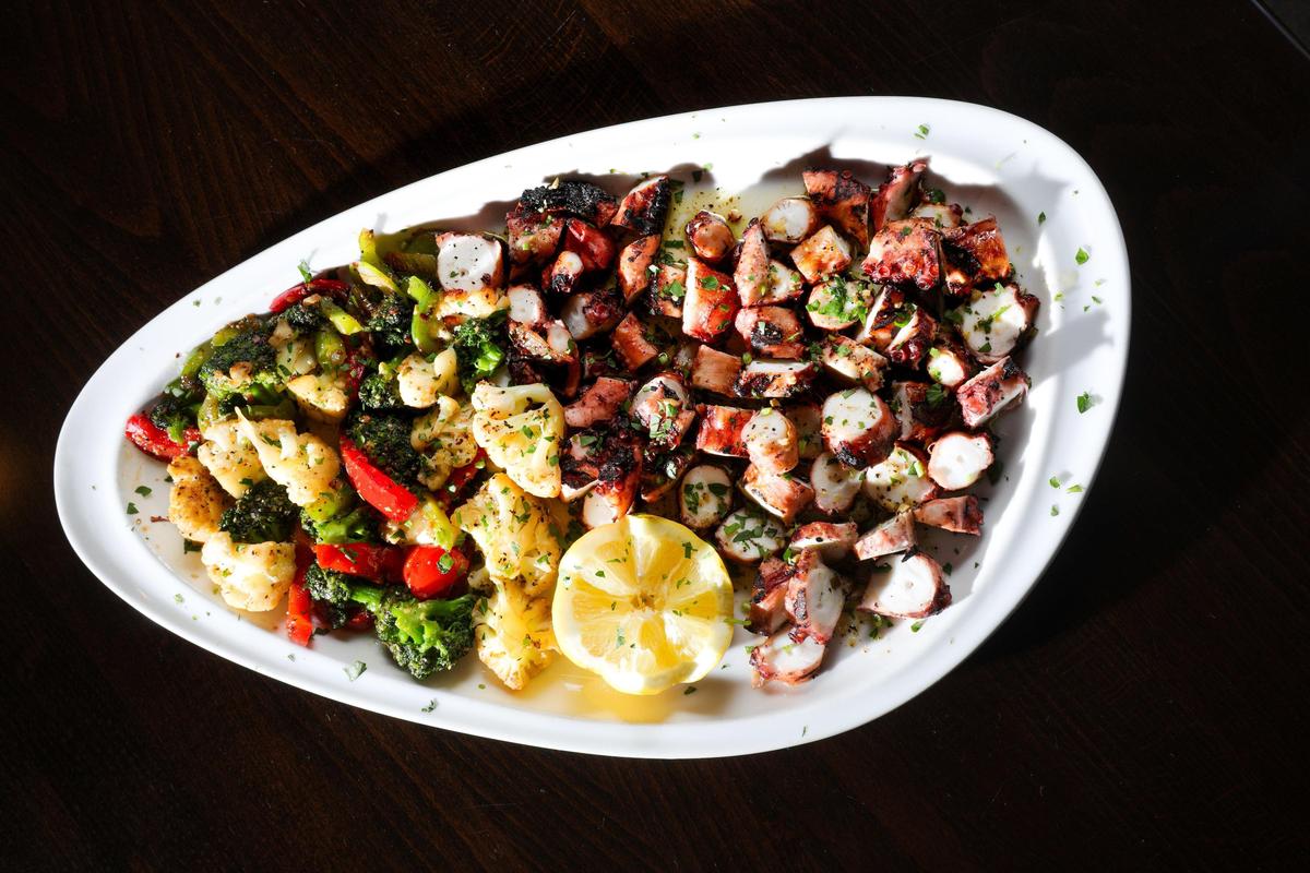 Tender grilled octopus is served with sautéed broccoli, cauliflower and roasted peppers, and topped with garlic and olive oil at Hapy Bistro in Pismo Beach.