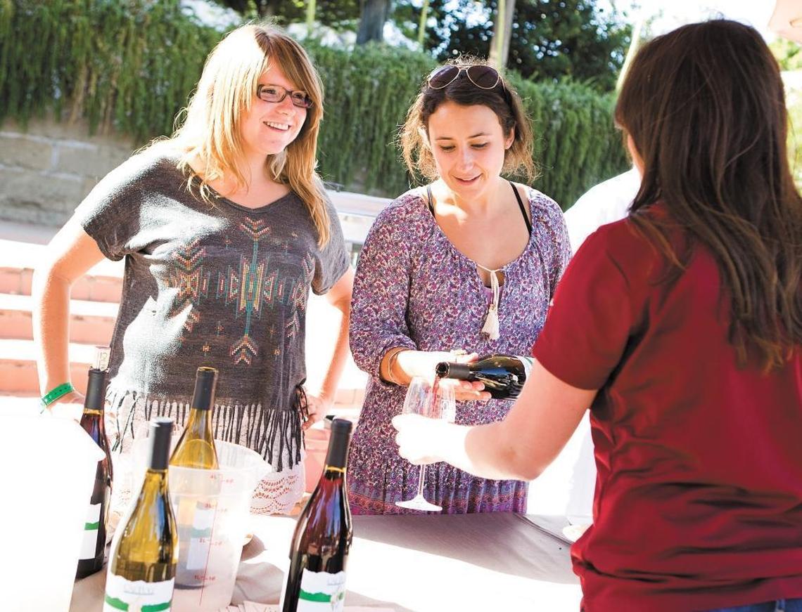 Kelly Allyn, left, and Ella Johnson pour Cal Poly-made wine at Barrels in the Plaza at Mission Plaza in San Luis Obispo, part of 2014’s Roll Out the Barrels. The festival returns in June 2017.