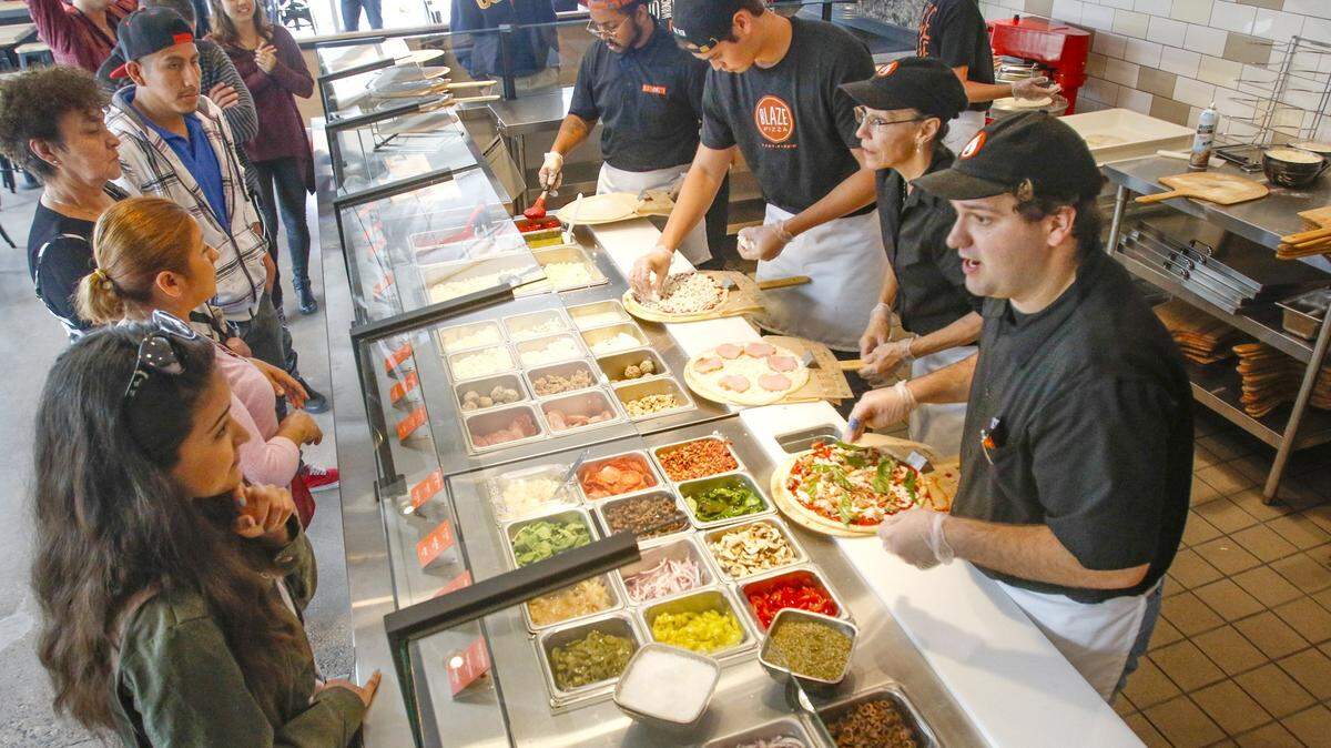Blaze Fast Fire’d Pizza opened its sixth Central Coast location in Arroyo Grande on Thursday. Employees prepare pizza for San Luis Obispo customers in this Tribune file photo.
