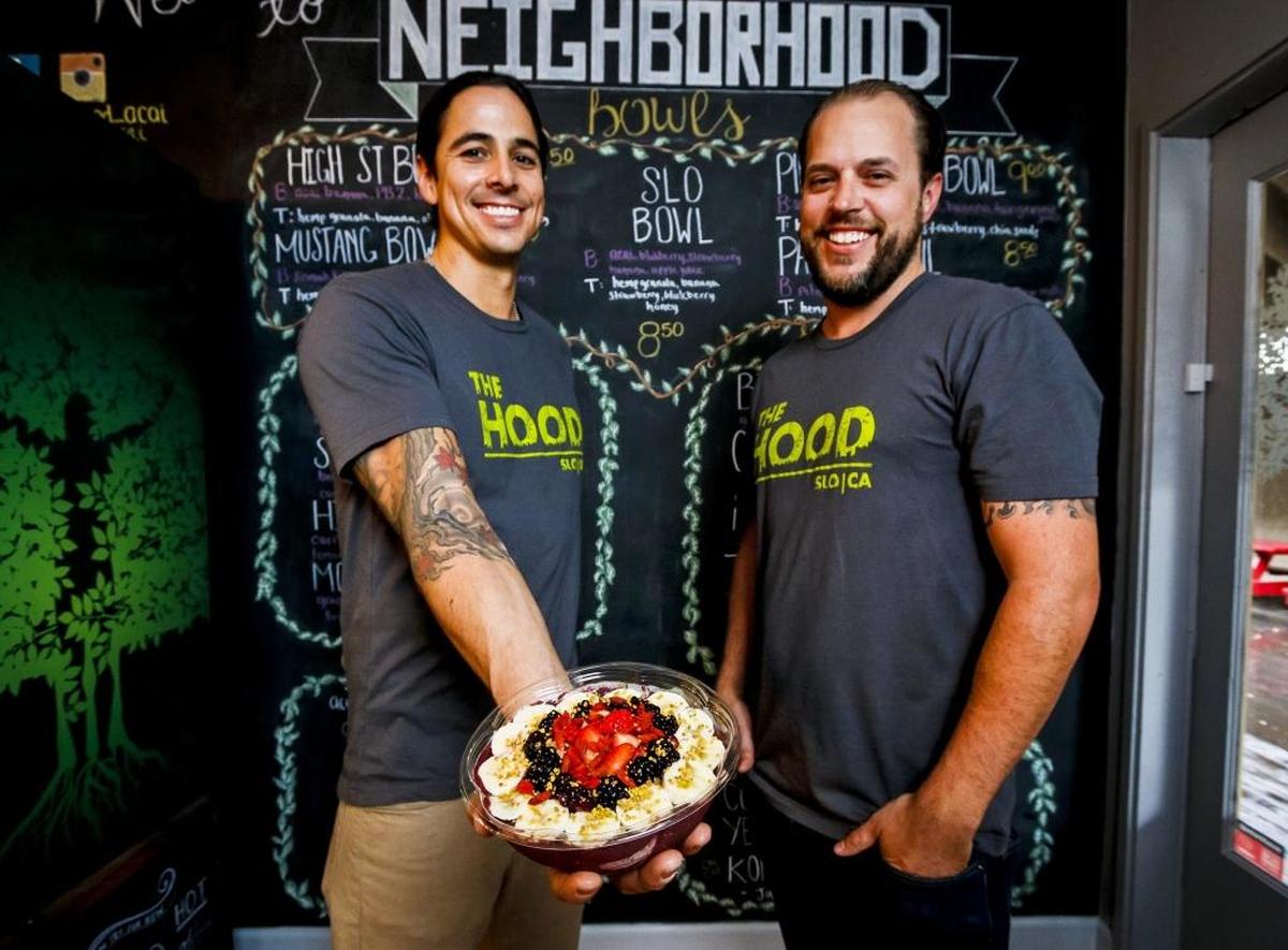 The Neighborhood Acai and Juice Bar owners Chris Herrera, left, and Doug Wells with their SLO Bowl. It features a base blend of acai, banana, blueberry, strawberry and apple juice topped with hemp granola, local honey and more banana, strawberry and blueberry.