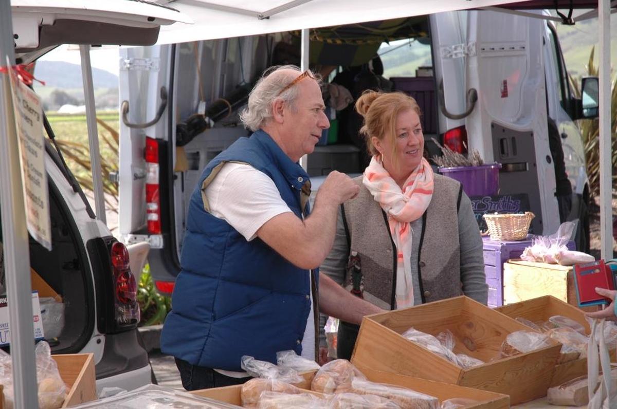 Franco Poletti and Ali Walsh, owners of La Migliore Italian Bakery in Paso Robles, chat with customers at the San Luis Obispo farmers market in 2017. The SLO Farmers’ Market returns Thursday.