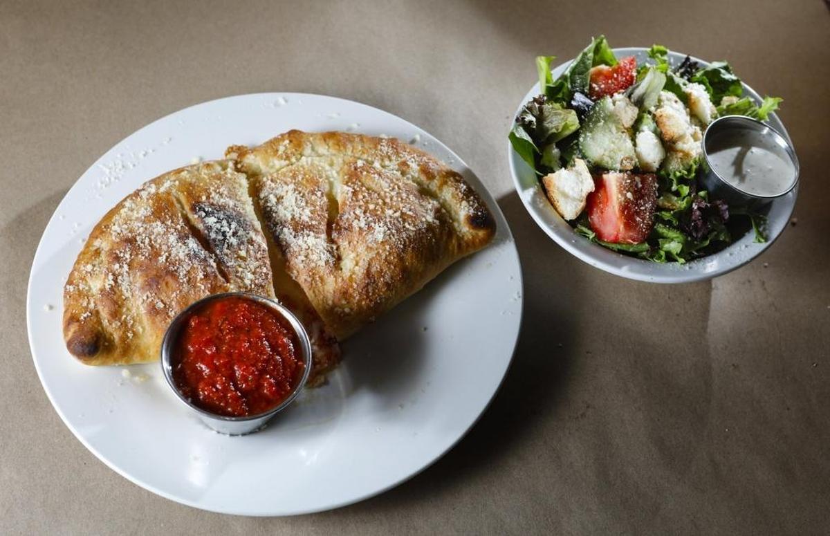 Menu options at Nardonne’s La Famiglia Pizzeria in Baywood and Atascadero include cheese calzone with a mixed green side salad.