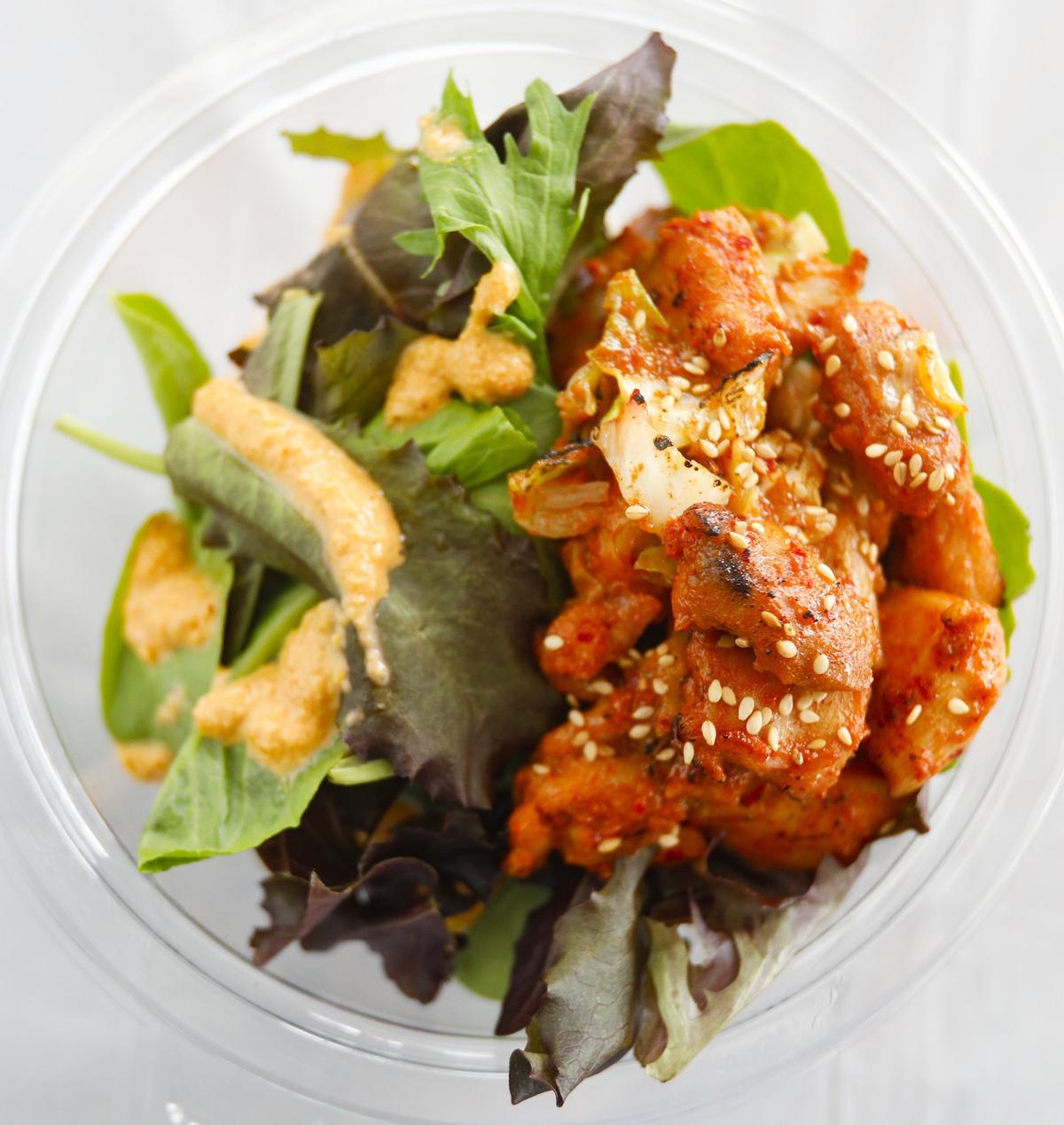 Fire chicken — chicken cooked in a spicy red pepper marinade — tops a Seoul bowl from Feed My Seoul food truck.