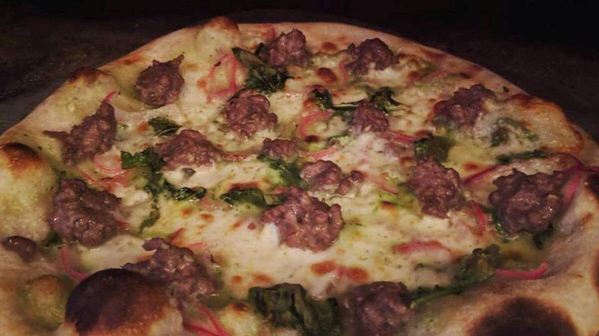 A lamb sausage flatbread at Ocean Grill in Avila Beach includes lemon thyme goat cheese cream sauce, pickled red onions and crispy arugula.