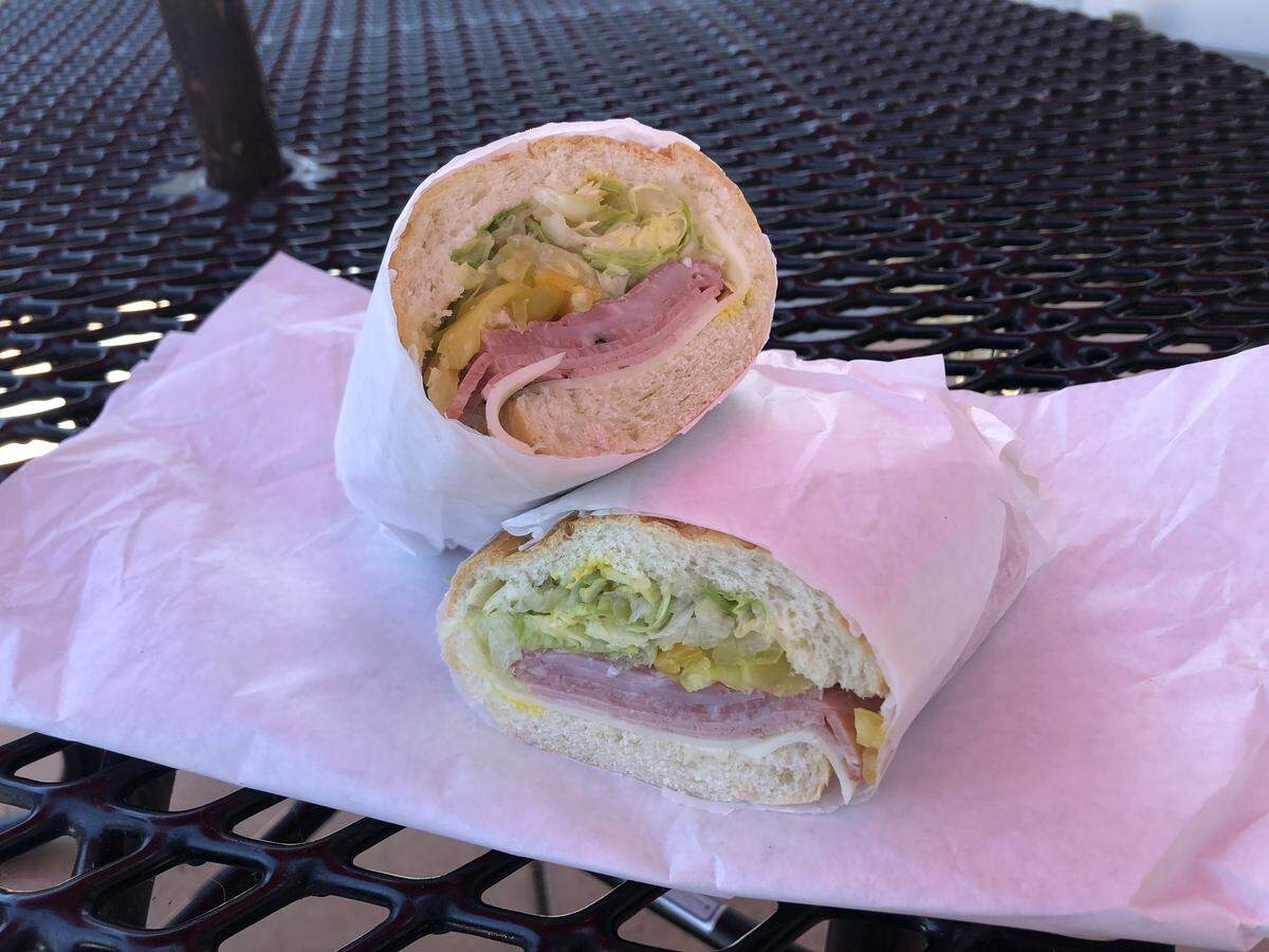 The SLO Town Special at Monterey St. Market in San Luis Obispo features dry and cooked salami, ham, mortadella and provolone cheese topped with banana peppers, tomato, mustard and mayo on a French roll.