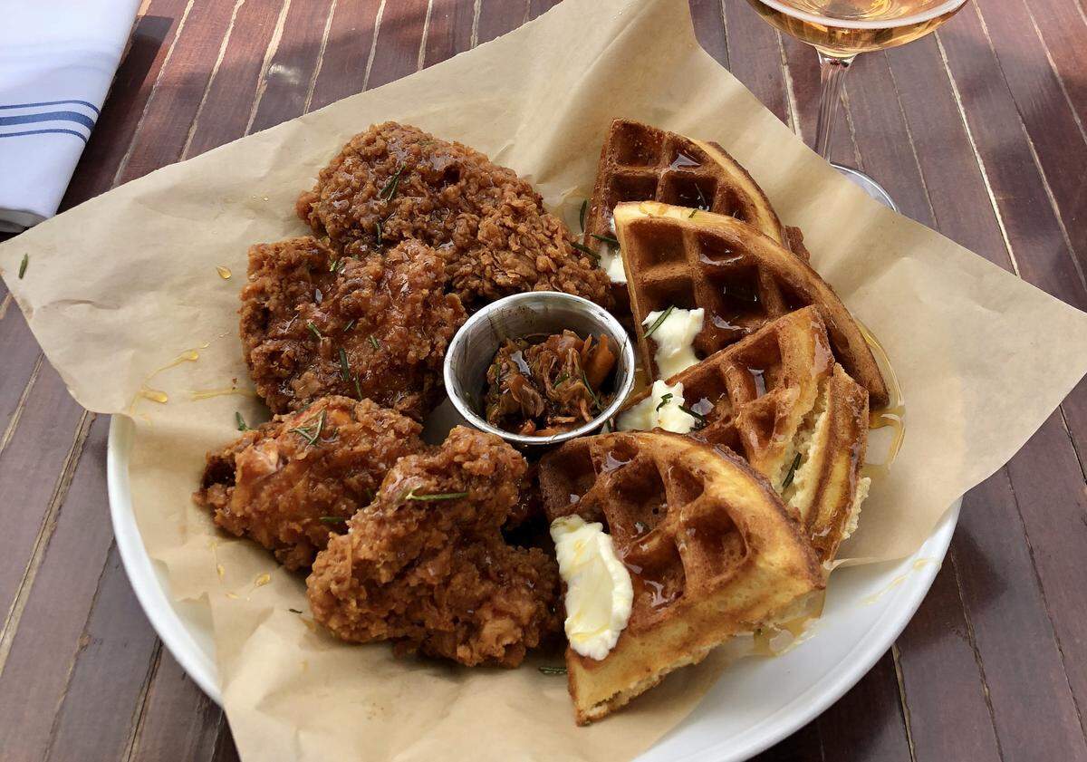 Honey-and-rosemary-coated fried chicken is served with asourdough waffle and a side of kimchi at The Spoon Trade in Grover Beach.