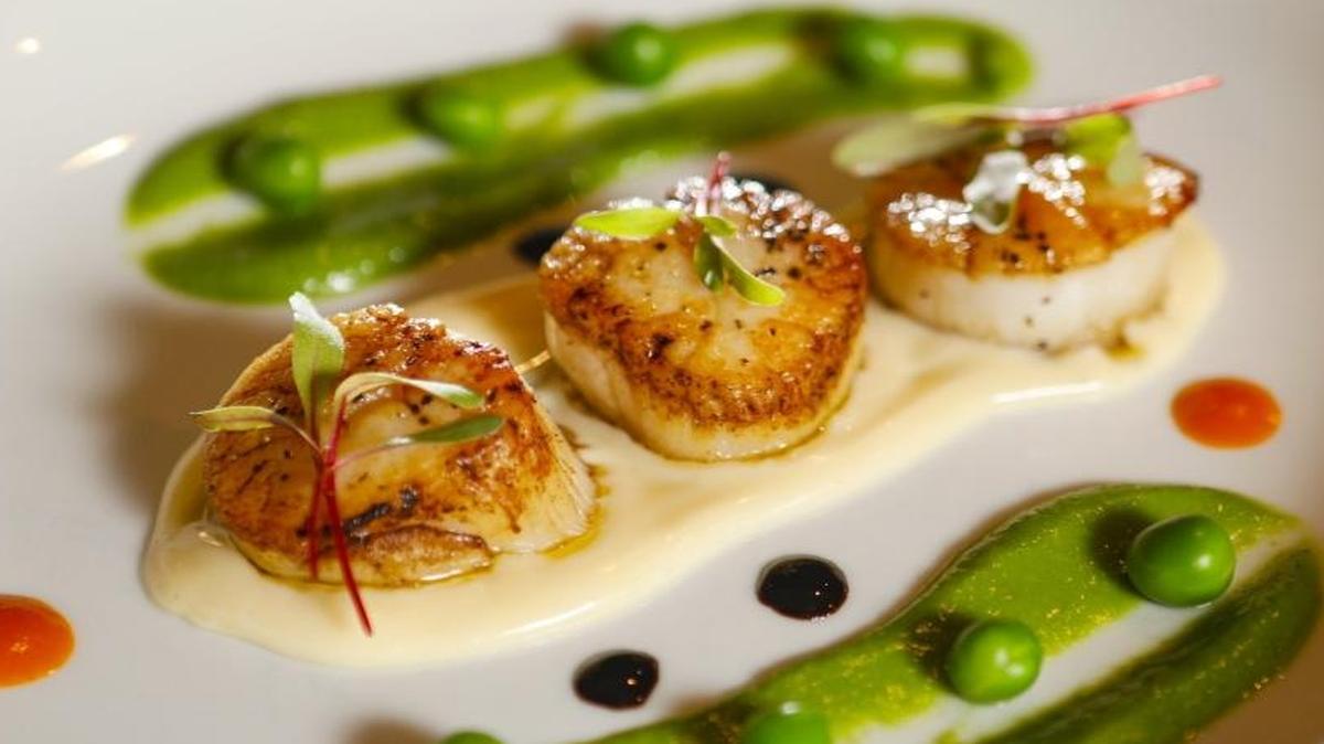 Seared scallops and sweet peas are served with parmesan fonduta at Il Cortile Ristorante in Paso Robles.