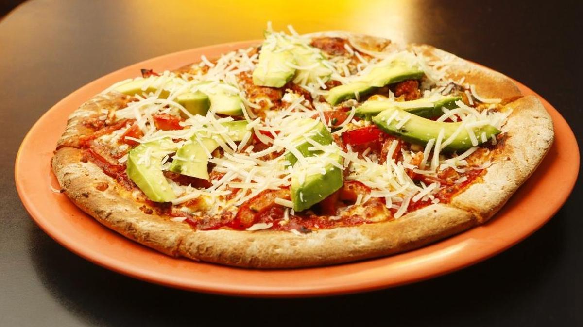 The Guido pizza at Pizza Solo in San Luis Obispo features marinated tomatoes, feta cheese, avocado, Parmesan cheese and marinara and pesto sauce.