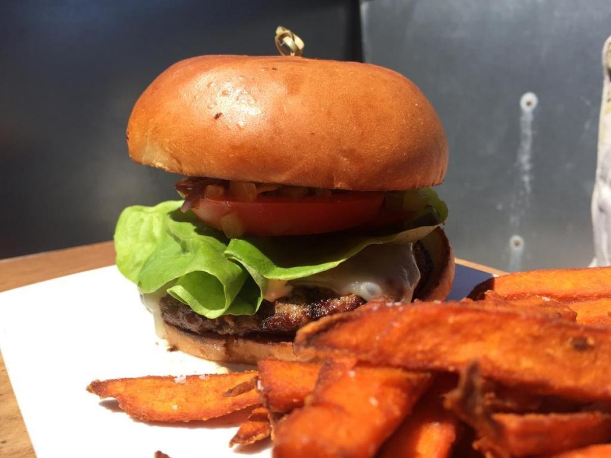 The Chop Classic burger features white cheddar, bibb lettuce, onion compote, tomato, dill pickle and Chop sauce.