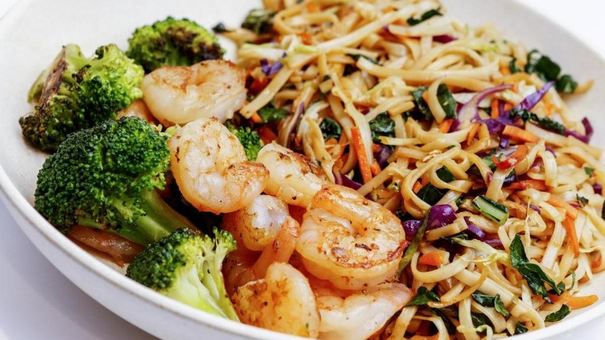 Hibachi shrimp and broccoli top brown rice noodles with kale, cabbage and carrot ribbons at Oki Momo Asian Grill in San Luis Obispo.