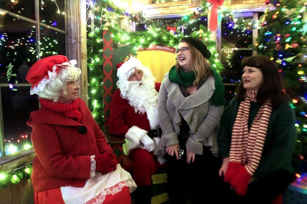 Marcia Thormey and her daughter, Ariel Bruce, visit Santa Claus and Mrs. Claus — Tom and Kelly Barton — at the Cambria Christmas Market. This year’s market runs Friday through Dec. 23 at the Cambria Pines Lodge.