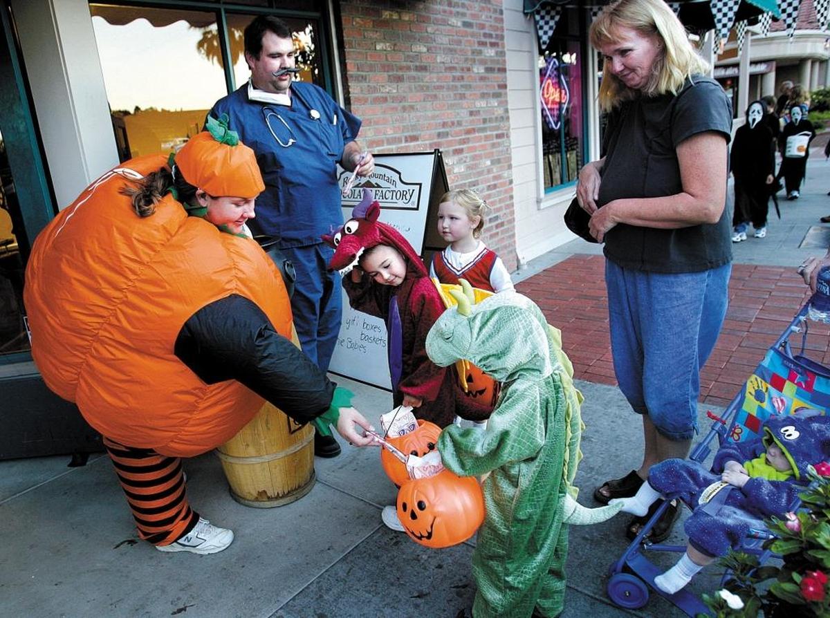 Jeff and Brooke Roby give out candy to trick-or-treaters in front of Rocky Mountain Chocolate Factory in downtown Paso Robles on Halloween in 2017. Safe & Fun Trick or Treat Downtown will be held Monday, Oct. 31, 2022.
