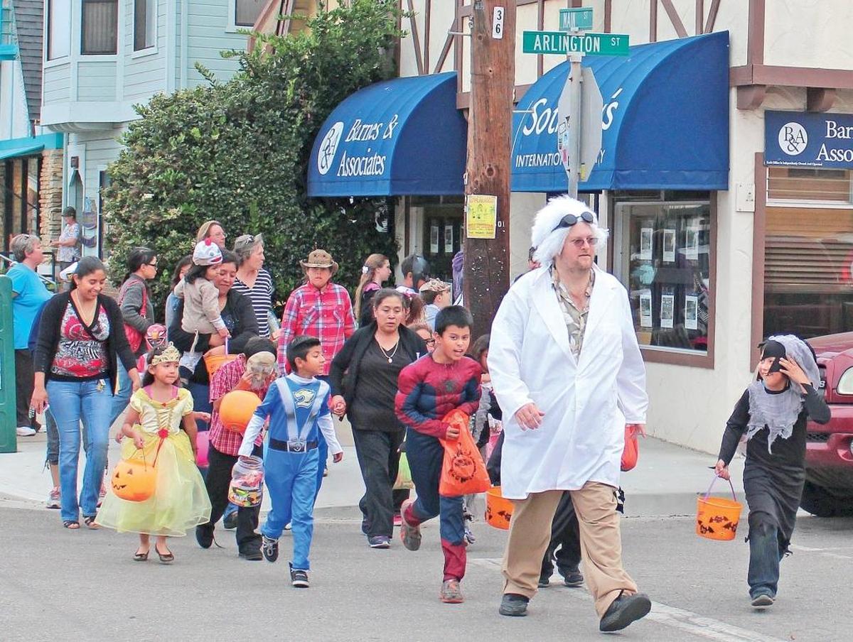 Rick Bruce, aka the Village Wizard, leads costumed youngsters down Main Street in Cambria during the annual Halloween parade. Bruce is dressed as Emmett “Doc” Brown from the “Back to the Future” movie trilogy.
