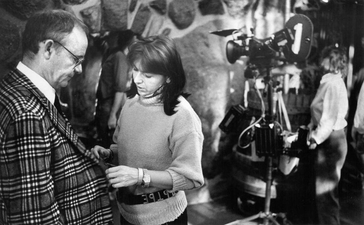 A crew member adjusts Buck Henry’s costume on the set of “Aria” at the Madonna Inn in San Luis Obispo in 1986.