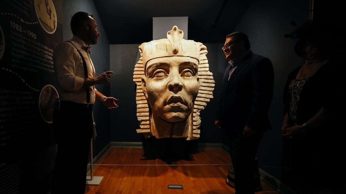 Executive director Doug Jenzen, left, and U.S. Rep. Salud Carbajal, talk about a plaster sphinx head unearthed from the long-buried set of Cecil B. DeMille’s silent movie “The Ten Commandments.”