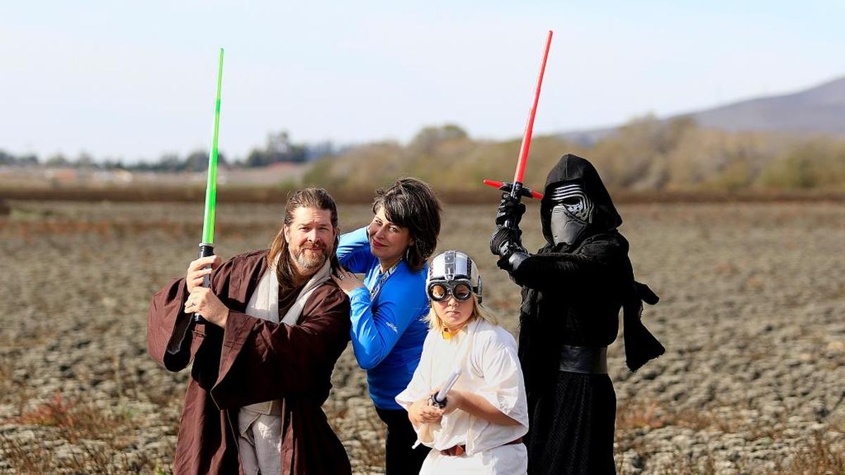 Shawn and Darci Hafley and their sons Spencer Hafley, 10, front, and Devlen Rourke, 15, right, stand in a dry Laguna Lake bed near their home dressed as their favorite characters from the “Star Wars” movies.