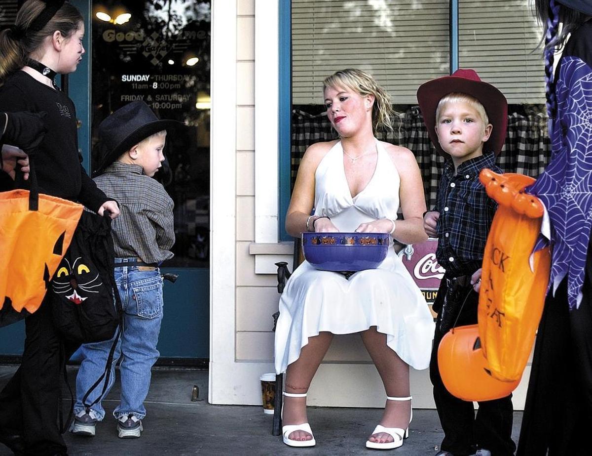 Jennie Lee, dressed as Marilyn Monroe, gets ready to hand out candy away to trick-or-treaters during the Safe & Fun Halloween Downtown in Paso Robles.