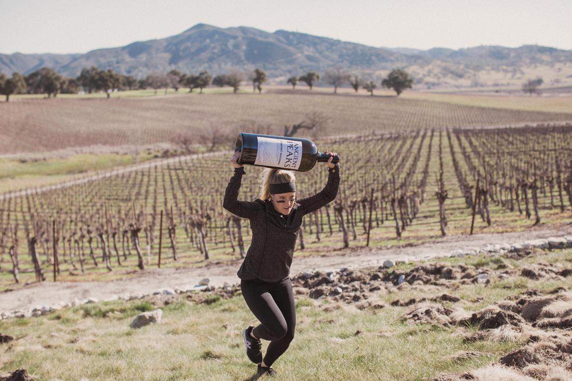 An employee at Ancient Peaks Winery in Santa Margarita carries a giant bottle of wine while training for a Spartan obstacle race. Santa Margarita Ranch will host several Spartan events, including 10-kilometer, 21-kilometer and 50-kilometer obstacle races, on March 14 and 15, 2020.