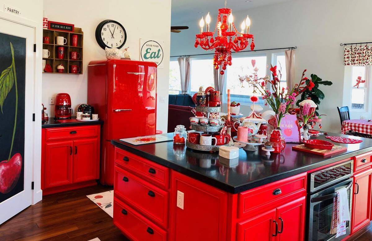 Black countertops ground red cabinets and kitchenware in the kitchen of Barb and Jeri Saia’s Los Osos home.