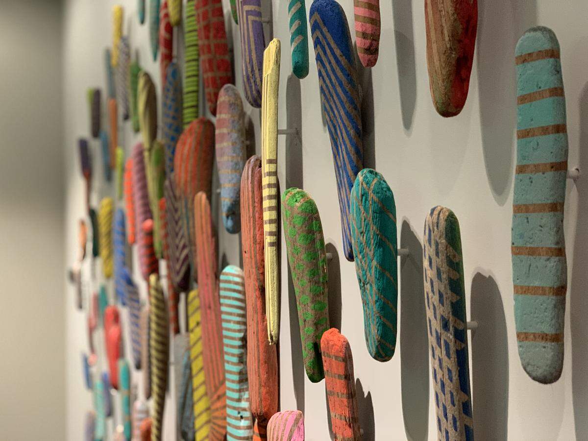 An art piece of found driftwood painted in various colors and patterns adorns a wall of a second-floor hallway at Hotel San Luis Obispo.