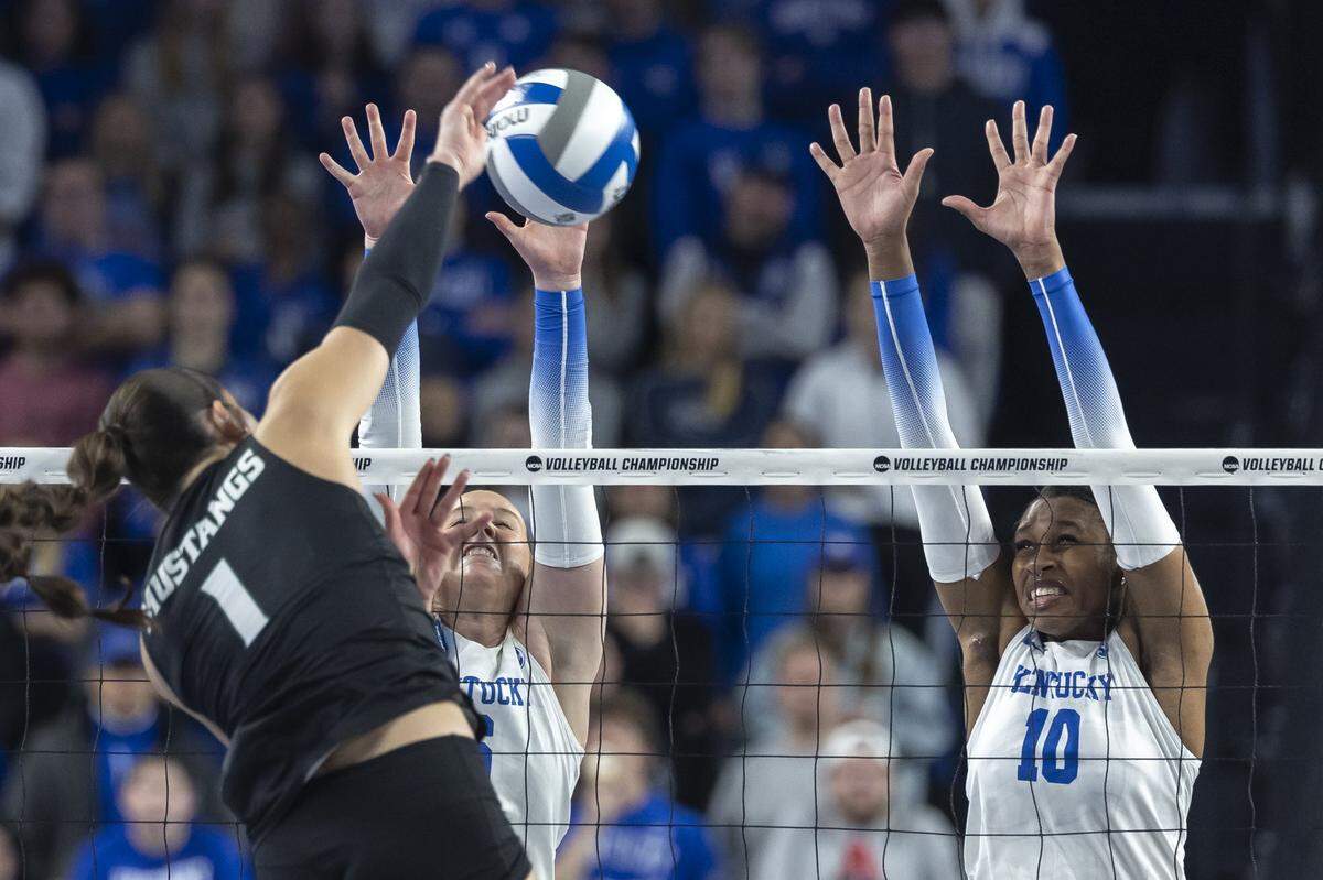 Cal Poly Mustangs outside hitter Emma Fredrick (1) hits the ball as Kentucky Wildcats setter Kassie O'Brien (6) and middle blocker Kennedy Washington (10) defend during the 2025 NCAA Volleyball Tournament Sweet 16 Lexington Regional at Historic Memorial Coliseum in Lexington, Ky., on Thursday, Dec. 11, 2025.