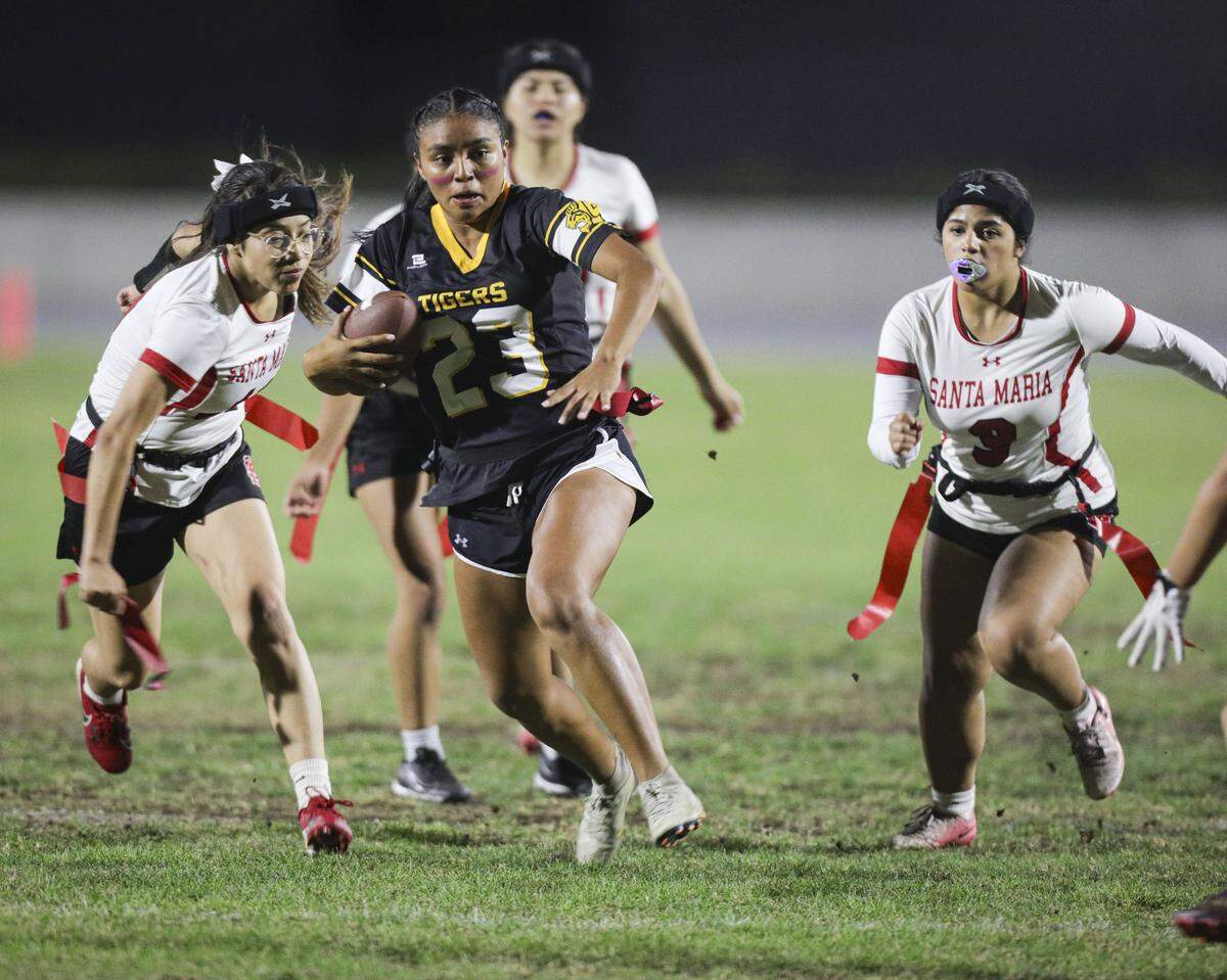 Sydney Rodriguez dodges flag pulls as she runs downfield. San Luis Obispo beat Santa Maria 51-6 in a girl's flag football game seen here on Oct. 16, 2025.
