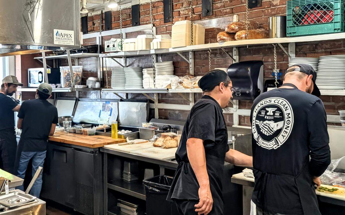 A kitchen crew prepares brunch service at AMSTRDM Coffee House in Paso Robles during the business’s recent grand opening weekend.