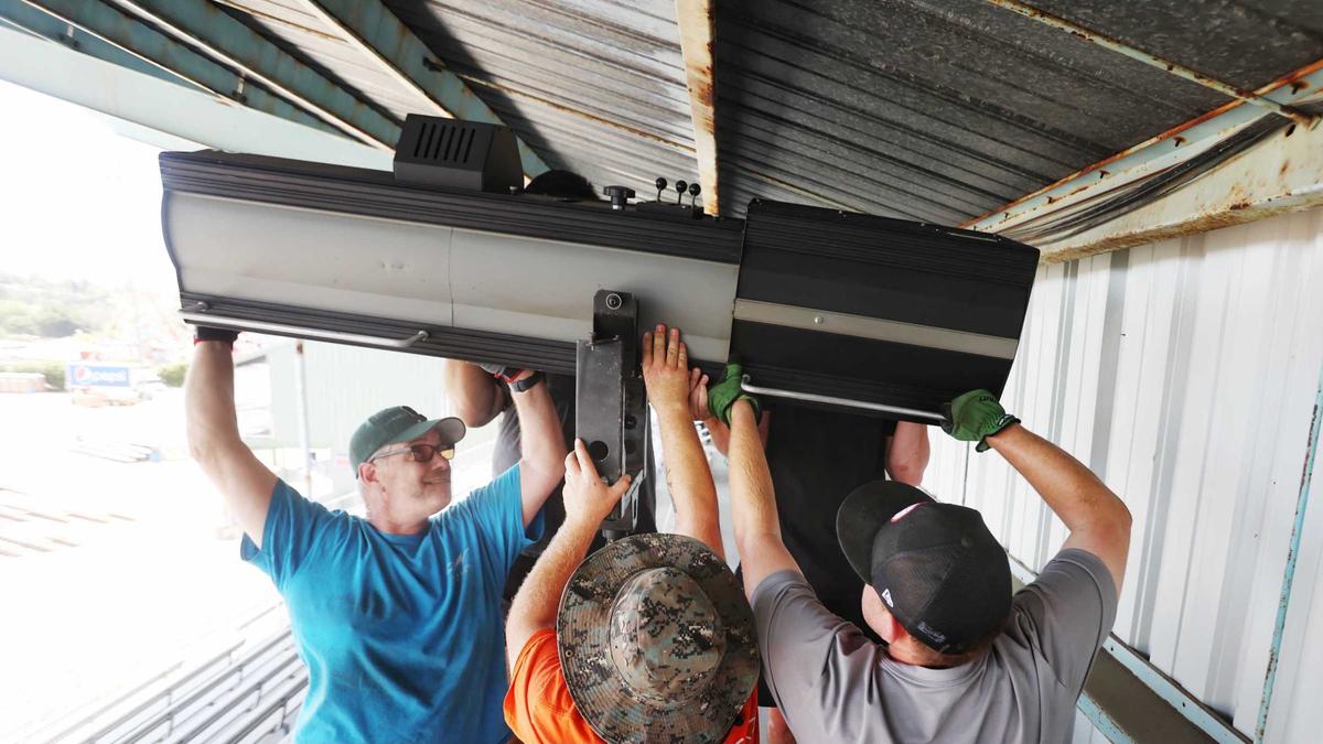 From left, Clark Stewart, Randal Bacon and Derrick Stewart set up a grandstand spotlight on Monday, July 19, 2021, as the California Mid-State Fair in Paso Robles prepares to open. Hidden in back are Sam Jiminez and Adam Salton.