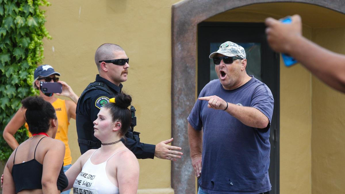 A man with a shirt reading “The Second Amendment ... America’s Original Homeland Security” on the back gets into a shouting match with marchers seated in intersection of 12th and Pine streets in Paso Robles on Tuesday, June 2, 2020. A Paso Robles police officer convinced the man to move on.