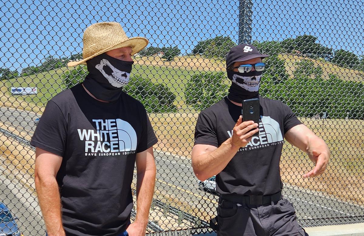 Several men with masks held up an “Embrace white pride” flag on the Vineyard Drive Highway 101 overpass on Saturday, May 13, 2023.